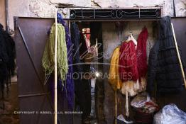 Image du Maroc Professionnelle de  Mohammed Ennaji âgé de soixante-dix ans, s'active à l'intérieur de son atelier à Marrakech, il a commencé à pratiquer ce métier de teinturier à l’âge de dix ans, cela lui fait soixante ans de métier un des plus ancien voir le vétéran des teinturiers, son atelier est situé au centre du Souk des Teinturiers, appelé souk Sebbaghine, l'un des plus pittoresque de Marrakech situé dans la Médina, non loin de la source Mouassine, où quelques petits ateliers pratiquent encore de nos jours la teinture traditionnelle. Ce lieu très prisé des touristes et amateurs photos qui désire ardemment des images extrêmement colorées. Avec le temps il est devenu presque une des attractions touristique qui vaut le détour. Derrière Si Mohammed Ennaji des écheveaux de laines sèchent au soleil suspendu en l’air ou le long des murs, le 8 Décembre 2018. (Photo / Abdeljalil Bounhar) 